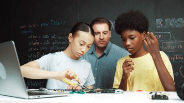 Kafkas öğretmeni elektrikli aletten bahsederken öğrenci de elektronik ekipmanlarla robot modelini tamir ediyor. Çeşitli akademik çocuklar ana kurul yapısını öğreniyor. Öğretim.