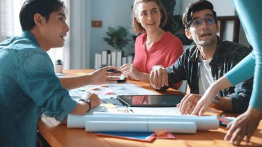 Profesyonel inşaat mühendisi planları incelerken belgeleri teslim etti. Planlarla toplantı masasında otururken fikir üretme ve bina dizaynını planlama konusunda yetenekli bir mimar takımı. Sempozyum.