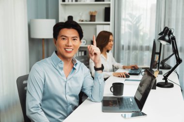 Akıllı Asyalı iş adamının profil profili modern ofisteki reklam alanı için kamera görüntüsü veriyor. Bulanık arkaplan bayan meslektaşım e-posta pazarlama raporunu kontrol etmek için bilgisayar üzerinde çalışıyor. İnfobahn.