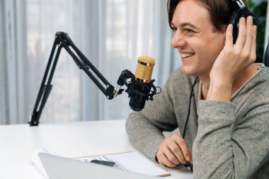 Sunucu kanalı, gülümseyen akıllı yayıncı kaydı, senaryosu ve akıllı telefonuyla sosyal medyada sohbet programı, kulaklık takarak modern ev stüdyosundaki video flamalarını kaydediyor. Bireysel.