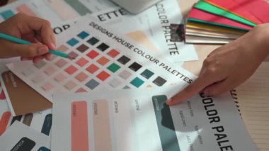 Grafik tasarımı için renk seçimi yapan ve beyin fırtınası yapan iki tasarımcının yavaş çekim çekimi ya da tasarım bürosunda kromatik danışmanlık hizmeti isteyen bir müşteri. Değiştirilmiş