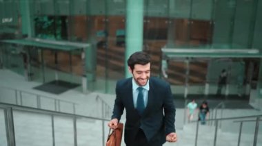 Terfi alma, satışları artırma, maaşları artırma konusunda iyi haberleri kutlamak için dans eden mutlu iş adamı şehirde geçmişi bulanık bir şekilde merdivenlerden çıkarken. Neşeli bir ruh hali. Sevinçli..