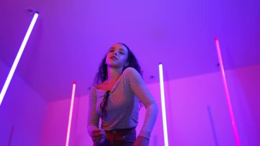 Latin dansçıların kameraya bakıp şehrin pop müziğiyle dans ettiği düşük açılı kamera. Profesyonel çekici hipster, mor veya neon ışıklı hip hop şarkısına geçiyor. Şık bir kumaş. Mutluluk.