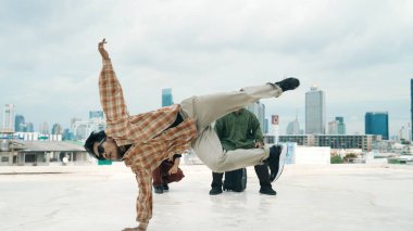 Çatıda çok kültürlü arkadaşlar varken profesyonel İspanyol break dansçısı B boy dansı. Genç modern dans grubu hip hop hareketi yapıyor. Tarz, moda, aksiyon. Açık hava sporu 2024 hiphop..