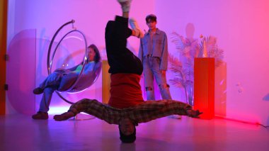 Arkadaş neon ışıklı dans stüdyosuyla performansı izlerken mutlu hipster kafa sallıyor. Zeki insanlar kameraya poz verirken profesyonel beyaz adam müziğe yöneliyor. Mutluluk.