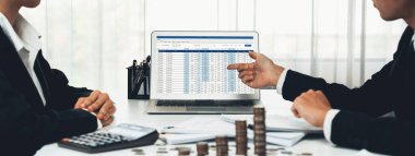 Kurumsal muhasebeci, vergi iadelerini hesaplamak ve maksimuma çıkarmak için dizüstü bilgisayar üzerinde muhasebe yazılımı kullanır ve Panorama 'daki iş yatırım yığını madeni para konseptiyle finansal performansı artırır. Kurnaz.