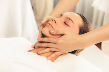 Kafkasyalı kadın stres önleyici kafa masajından ve lüks tatil beldesi ya da otel spa salonundaki modern ışık ortamında yüz güzelliği eğlencelerini şımartmaktan hoşlanıyor. Sessiz.