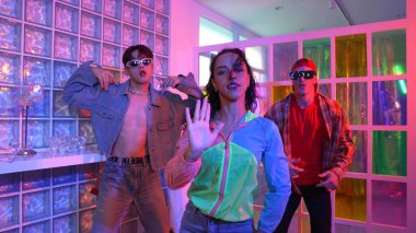 Değişik takımlarla dans ederken süslü gözlük takan yakışıklı hippi serbest stil müzikle mutlulukla dans ediyor. Beyaz hipster kulüpte parlak neon ışıkta sokak dansı yapıyor. Mutluluk.