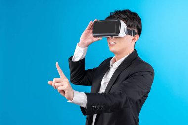 Asyalı işadamı, sanal gerçeklik mavi telif uzayı yenilik teknolojisini analiz eden gelecekçi metaevrendeki iş dünyası raporuna dokunarak ekranı titizlikle inceliyor. Entrika.