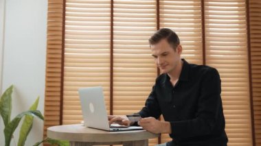 Genç adam internet bankacılığı için kredi kartlı dizüstü bilgisayar kullanıyor. İnternet üzerinden alışveriş yapıyor. Banka kartıyla modern ve kullanışlı online satın alma. Düzenle