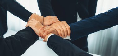 Ofis çalışanlarının el ele dizilmesi başarılı bir iş ortaklığı grubunu ve panoramik pankartta kamu işyerinde güçlü bir birlik takım çalışmasını sembolize ediyor. Kurnaz.