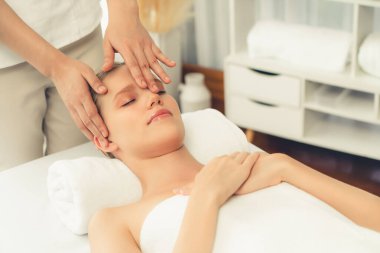 Kafkasyalı kadın stres önleyici kafa masajından ve lüks tatil beldesi ya da otel spa salonundaki modern ışık ortamında yüz güzelliği eğlencelerini şımartmaktan hoşlanıyor. Sessiz.