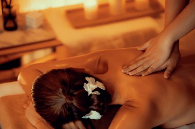 Beyaz kadın müşteri stres önleyici spa masajının keyfini çıkarıyor ve lüks otel ya da otelde sıcak mum ışığında güzellik teniyle eğleniyor. Sessiz.