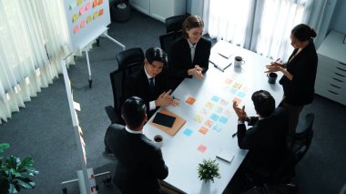 Akıllı yönetici finansal grafiğinin üst görüntüsünden çeşitli takımlara geçerken, bir grup çok kültürlü iş adamı toplantıda hisse yatırım grafiği kullanarak pazarlama stratejisi planlıyorlar. Müdürlük.