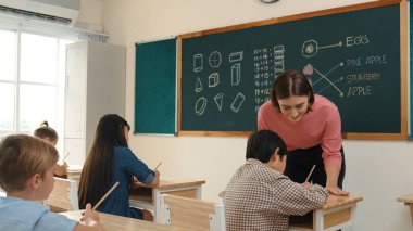 Zeki öğretmen sınıfta fikri açıklarken sevimli öğrenci ödevlerini kontrol ediyor. Not defterine bakıp matematik teorisinden çocuğa bahsederken sınıfta dolaşan çekici bir eğitmen. Pedagoji.