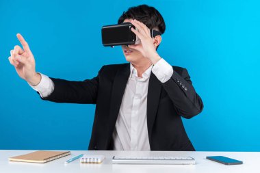 Asyalı işadamı dokunmatik ekran hologram monitörünü fütüristik metaevrende analiz ederek yenilik teknolojisi iş dünyası sanal gerçekliği mavi telif alanını izole ediyor. Entrika.