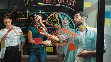 Yetenekli erkek lider, istatistik grafiğini uzman yatırımcılara açıklıyor. Akıllı iş adamı sunar, finans planlarını gece ofisindeki cam duvardaki yatırımcılara gösterir. İş konsepti. İzleme