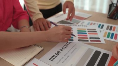 Grafik tasarımı için beyin fırtınası yapan ve renk seçimi yapan tasarımcı ekibinin yavaş çekim çekimi veya tasarım bürosunda krom danışmanlığı için danışmanlık isteyen bir müşteri. Değiştirilmiş