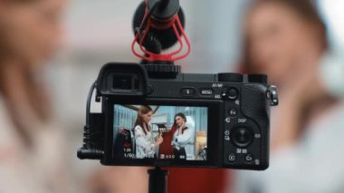 Arka görünüm, kamera ekranının arkasında iki kadın nüfuzlu görüntüleyicinin video görüntülerini, video görüntülerini, kıyafetleri, sosyal medyayı ya da blogu görüntülemesini gizler. Canlı yayın için stüdyo ışıklandırmalı kızlar canlı yayın pazarlama kayıt oturumu