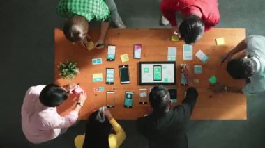 Ux ui tasarımını renkli yapışkan nota üzerine yazmak için birlikte çalışan geliştirici ekibinin üst görüşü. Tablet 'te kablo prototipi inceleyen ve yazılım tasarlayan bir grup programcı. Cemaat.