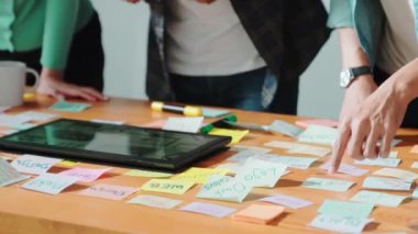 Dizüstü bilgisayara bakan ve logo tasarımını işaret eden yetenekli bir iş ekibi ana tema rengini seçme ve pazarlama kampanyasını planlama kararı alıyor. Birlikte çalışan akıllı bir grup. Sempozyum.