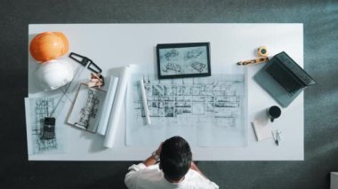 Güvenlik kaskı, dizüstü bilgisayar ve ekipmanlarla başarılı bir proje için toplantı masasında el kaldırırken cep telefonu kullanarak yöneticiyle konuşan yetenekli mühendisin alt görüşü. Hizalama.