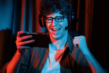 Genç oyun flaması takımı, Esport ile birlikte akıllı telefon dövüşünde kazanan oyuncuları Neon Light Room 'da kulaklık takarak online yapıyor. Bir sonraki seviyeye rakip kazanmak için strateji planı uyguluyorum. Toplayıcı.