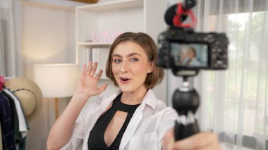 Kadın nüfuzlu kişi video görüntülerini canlı yayınlıyor. Kıyafetler sosyal medyada ya da blogda yer alıyor. Stüdyo ışıklandırmalı mutlu genç kız çevrimiçi pazarlama oturumu yayını için..