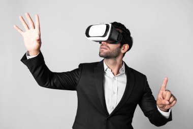 VR gözlük ve takım elbise giyerken veri analizine bakan yetenekli bir iş adamı. Proje yöneticisi görsel gerçeklik gözlüğü ya da kulaklık kullanırken kontrol ediyor ve seçiyor. Yenilik teknolojisi. Sapma.