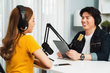 Gülümseyen radyo etkili sunucu elinde tablet, kulaklık takıyor kadın konuşmacı sosyal medya online canlı yayın kanalı ile röportaj yapıyor ve sabah stüdyo kaydında paylaşım linkini paylaşıyor. İnfobahn.