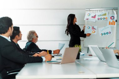 Uluslararası iş konferansında grup toplantı odasının önünde duran iş kadınının sunumunu dinleyen Asyalı işadamları. Çok kültürlü kurumsal strateji kavramı. uds