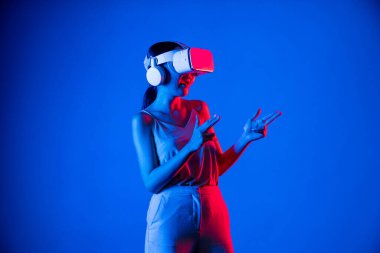 VR kulaklık takan zeki bir kadın metaevrene bağlanıyor, gelecekteki siber uzay topluluğu teknolojisi. Sanal silaha hükmeden zarif bir kadın ciddi ciddi oyun oynuyor. Halüsinasyon.