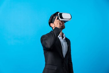 Kafkasyalı iş adamı, sanal gerçeklik gözlüğü kullanırken finansal plan yapıyor. Görsel gerçeklik gözlüğü kullanarak metaevreni bağlarken profesyonel proje yöneticisi ayakta ve VR kulaklığına dokunuyor. Sapma.