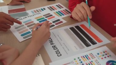Tasarımcı ekibinin beyin fırtınası yaptığı ve grafik tasarımı için renk seçimi yaptığı el kapanışı ya da tasarım bürosunda krom danışmanlığı için danışmanlık isteyen bir müşteri. Değiştirilmiş