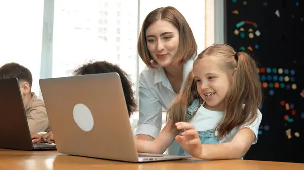 stock image Multicultural smart student using laptop writing engineering code while teacher explain and teaching about program. Professional instructor helping learn programing system at STEM class. Erudition.