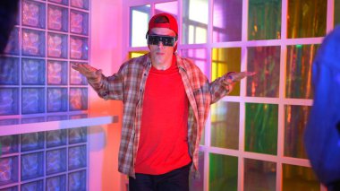 Kafkas dansçısı dans ederken çeşitli arkadaşları gece kulübünde neon ışıkta ayak seslerine bakıyor. Çoklu etnik kökenli hipsterin serbest stil müziğe geçişi ve mutlu bir adamın kameraya bakışıyla. Mutluluk.