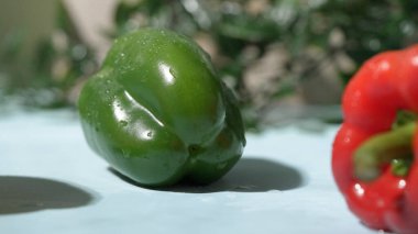 Mavi arka planda su damlacıkları olan taze yeşil dolma biber, sarı dolma biber, makro fotoğraf. Sağlıklı beslenme ve taze üretim kavramı. Yemek reklamı için tasarım. Pabulum.