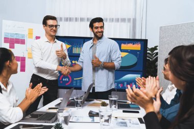 Analist ekip lideri, iş zekası ya da BI gösterge paneli ile FIntech yazılım gücünü kullanarak başarılı veri analizi toplantısından sonra iş arkadaşıyla tokalaştı. Tedbirli