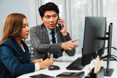 İş ortağıyla cep telefonundan arayan işadamı bilgisayardaki kadın iş arkadaşıyla hisse senedi değer veri tabanını hesaplarken şirket değerini analiz ediyor ya da güncel alım yapıyor. İnfobahn.