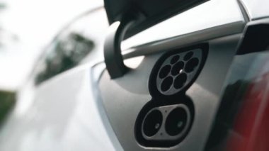 EV şarj prizi kapağı elektrikli arabaya bağlanıyor, EV araba aküsünü temiz çevre için sıfır CO2 emisyonu ile alternatif ve sürdürülebilir enerjiyle şarj ediyor. Titiz