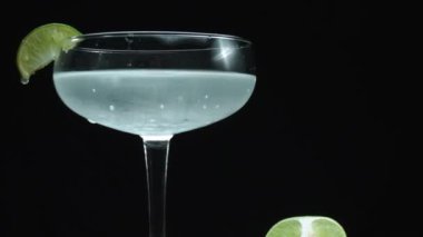 Makrografi, cezbedici bir margarita canlı bir limon dilimi ile süslenmiş bir bardakta yakalanır, hepsi büyüleyici bir siyah arka plana karşıdır. Her yakın çekim kokteyl ve limon. Geliştirilebilir.