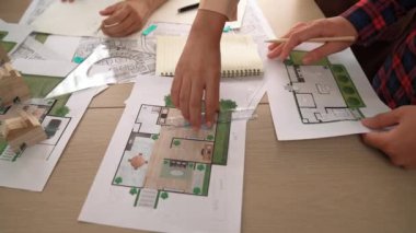 Akıllı mimar ya da akıllı mühendisin ölçüm aracı ve kalem el kullanarak mimari ofisindeki inşaat isabet planı üzerine detaylı bir yazı yazışının videosu. Eline odaklan. - Yakın çekim. Tanımlama.