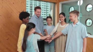 Kafkas öğretmeni ve çeşitli çocuklar sınıfta ayakta dururken başarılı projeyi kutlamak için el ele tutuşuyorlar. Aşkı, takım çalışmasını, güveni, birlikteliği ve birliği temsil et. Öğretim