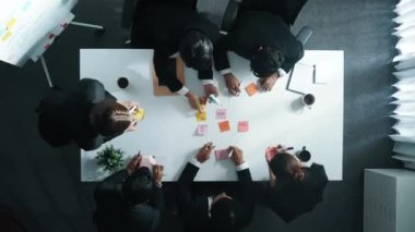 Çeşitli iş grupları pazarlama planını yapışkan notlar kullanarak tartışır. Girişim projesinde çeşitli grupların beyin fırtınaları ve finansal stratejilerinin zaman aşımı. Müdürlük.