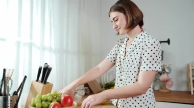 Çekici beyaz anne salata yapmak için taze sebze doğruyor. Mutlu enerjik akıllı anne kahvaltıda sağlıklı yemek pişirirken modern mutfakta çalışıyor. Yemek hazırlama konsepti. Pedagoji.