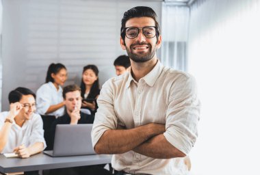 Ofiste çalışan iş arkadaşı ve iş adamlarının geçmişine sahip özgüven ve mutlu gülümseyen iş adamı portresi. Ofis çalışanı takım çalışması ve pozitif iş yeri konsepti. Tedbirli