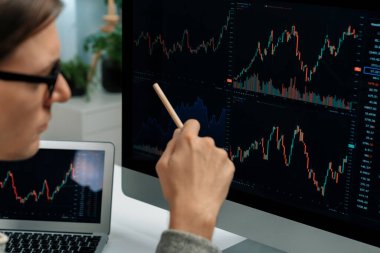 Akıllı yatırımcılar bilgisayar ekranlı ilginç borsa takasını işaret ediyorlar. Finansal teknoloji dinamik yatırım planı modern işyerindeki veri grafiğine odaklanıyor. Bireysel.