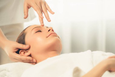 Kafkasyalı kadın stres önleyici kafa masajından ve lüks tatil beldesi ya da otel spa salonundaki modern ışık ortamında yüz güzelliği eğlencelerini şımartmaktan hoşlanıyor. Sessiz.