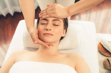 Kafkasyalı kadın stres önleyici kafa masajından ve lüks tatil beldesi ya da otel spa salonundaki modern ışık ortamında yüz güzelliği eğlencelerini şımartmaktan hoşlanıyor. Sessiz.