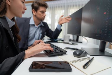 İki tüccar, dinamik borsada döviz oranı yatırım programı web sitesini iki bilgisayar ekranında analiz ediyor. Modern ofisteki gerçek zamanlı grafiği karşılaştırmak isteyen bir kadın. Varsayım.